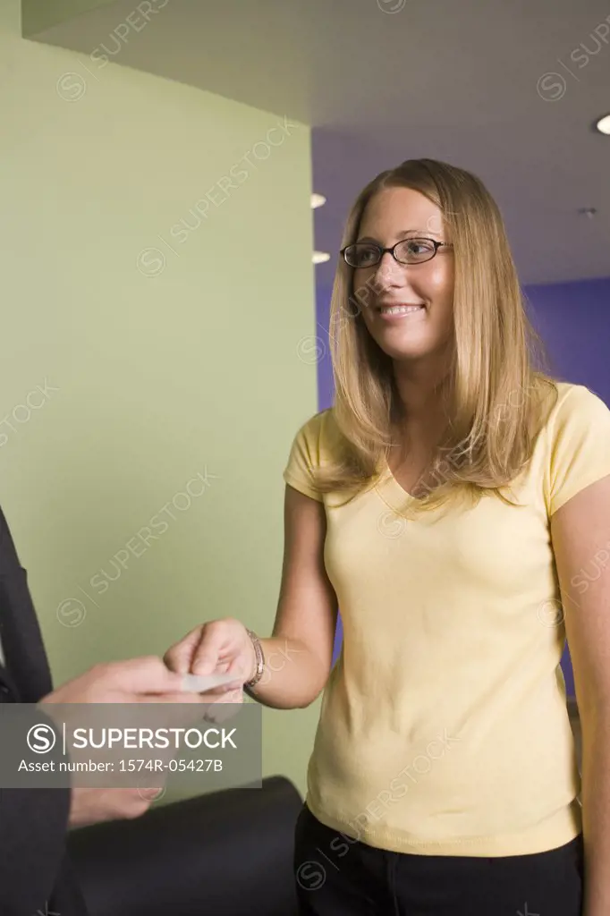Businesswoman giving a business card to a businessman