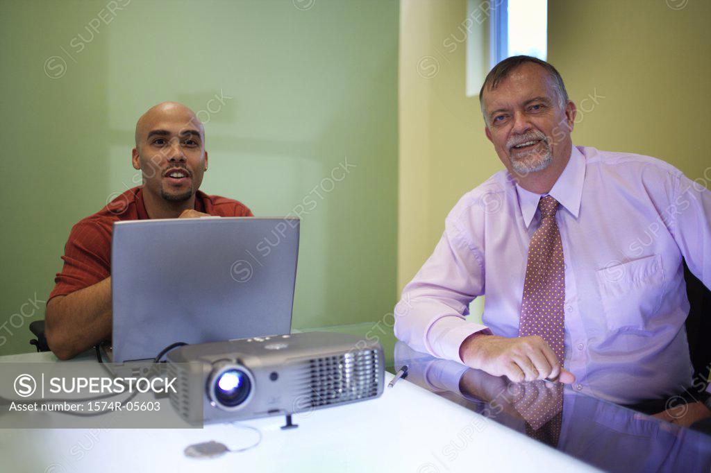 Stock Photo: 1574R-05603 Two businessmen smiling during a slide presentation