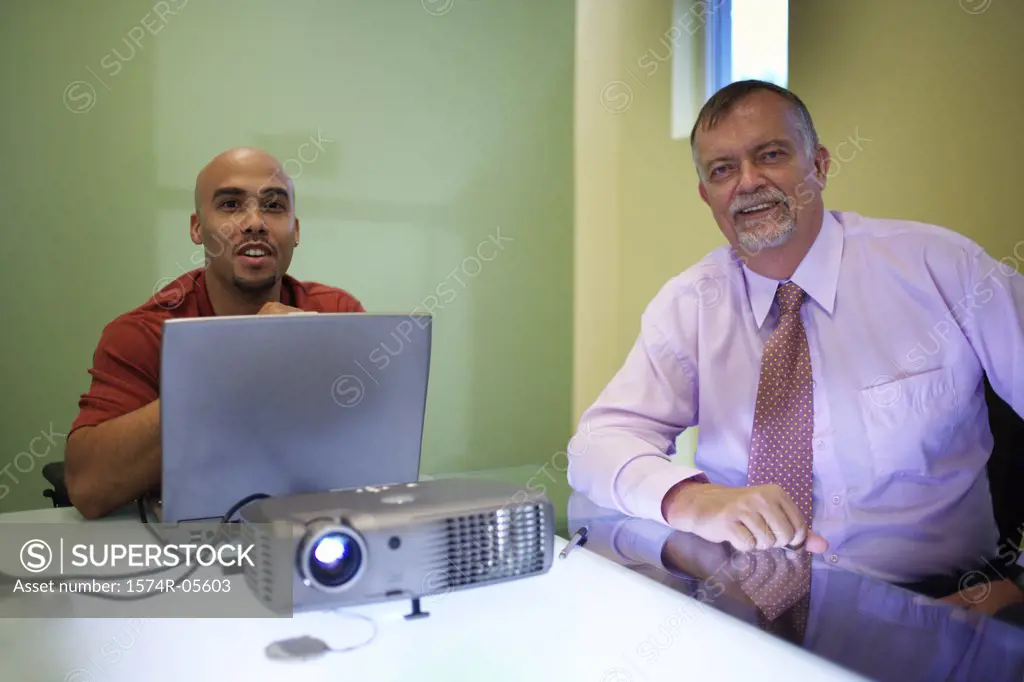 Two businessmen smiling during a slide presentation