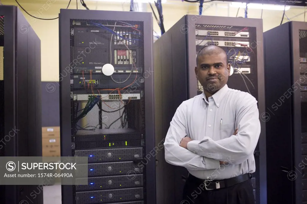 Portrait of a technician standing in front of network servers