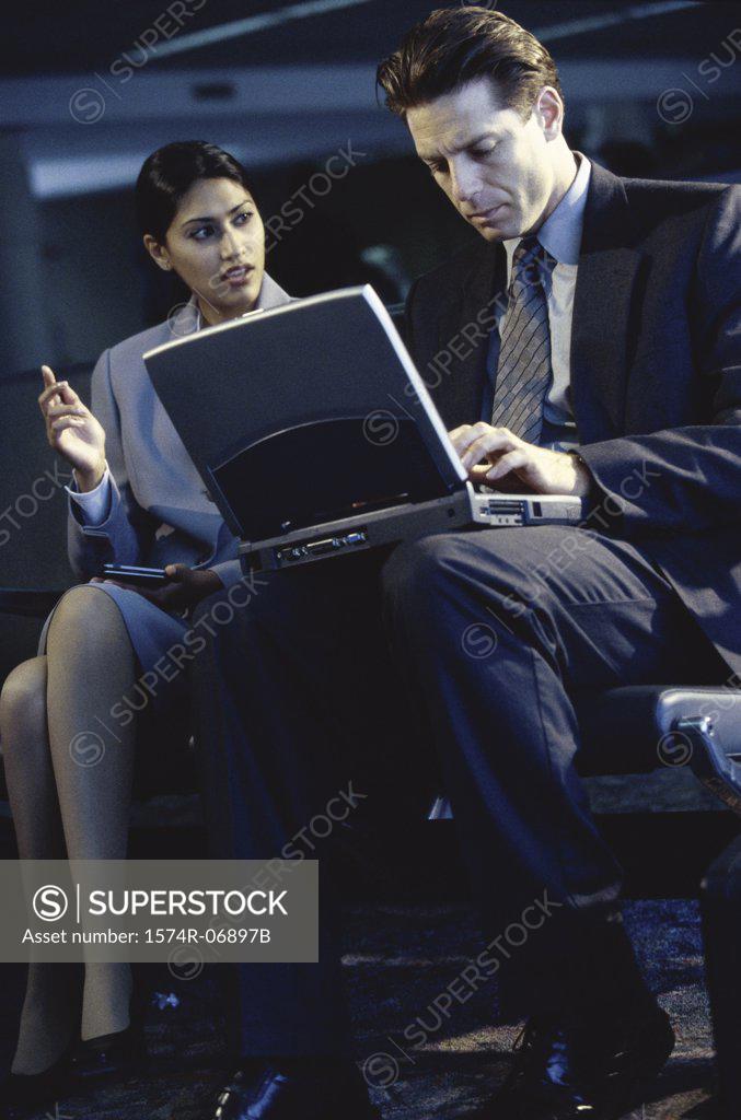 Stock Photo: 1574R-06897B Side profile of a businessman and businesswoman sitting in front of a laptop