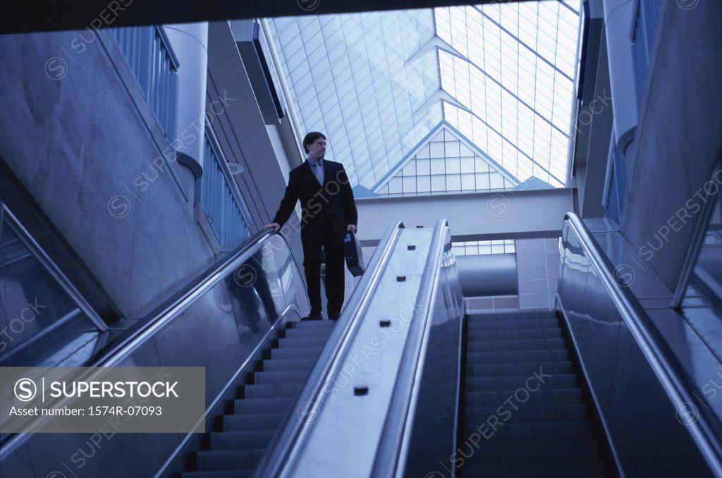 Stock Photo: 1574R-07093 Low angle view of a businessman on an escalator
