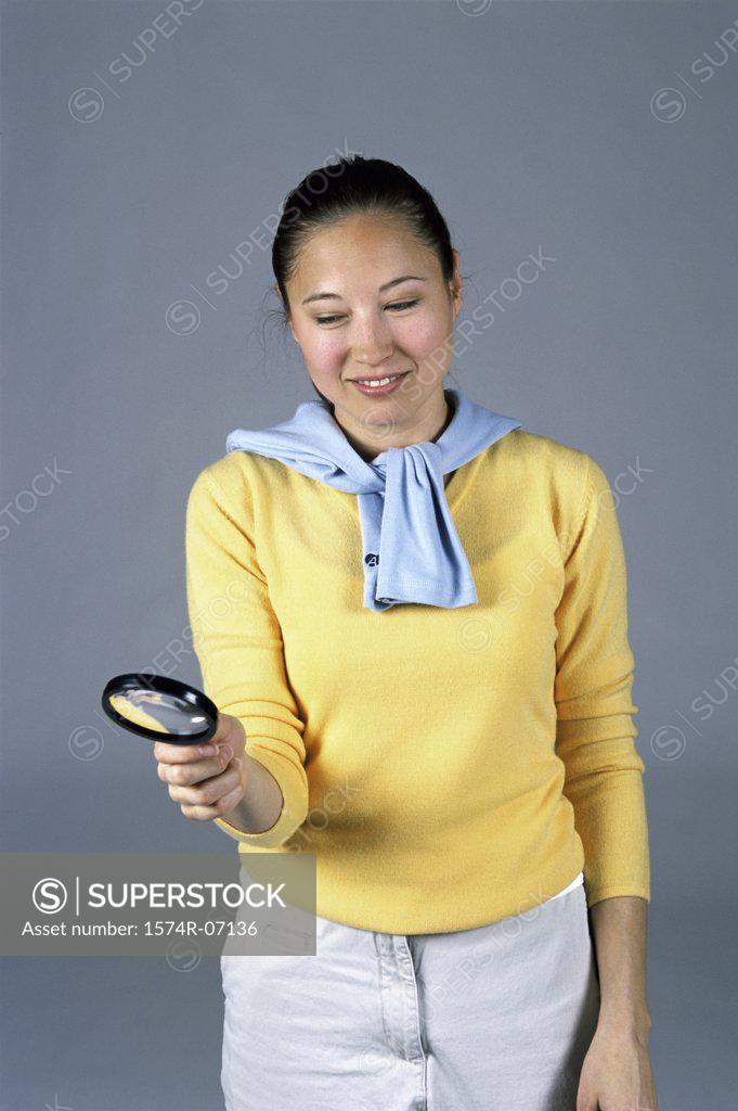 Stock Photo: 1574R-07136 Woman holding a magnifying glass
