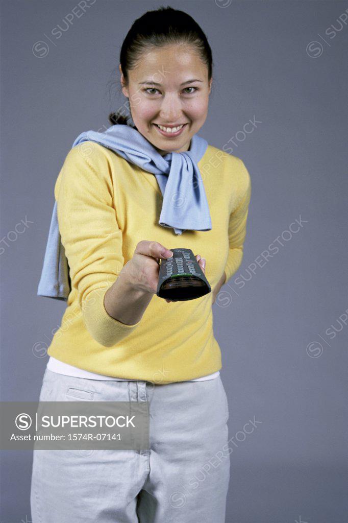 Stock Photo: 1574R-07141 Portrait of a young woman holding a remote control
