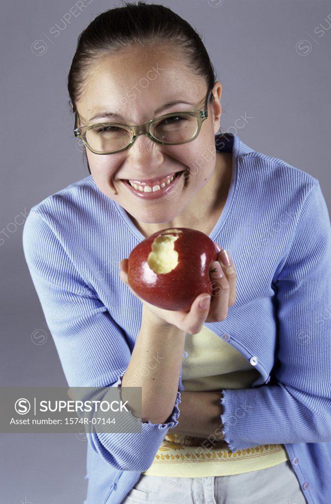 Stock Photo: 1574R-07144 Portrait of a teenage girl holding an apple smiling