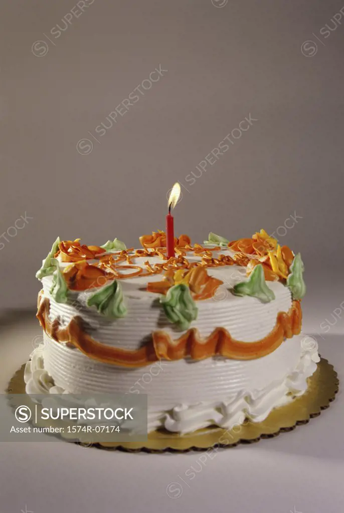 Decorated birthday cake with a lit candle