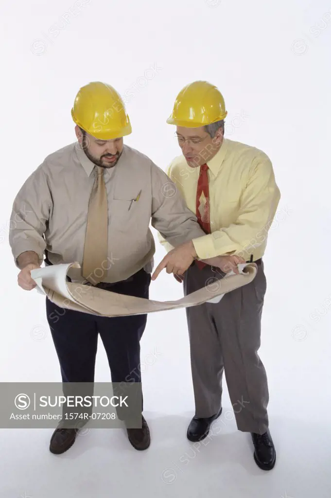 High angle view of two foremen working on blueprints