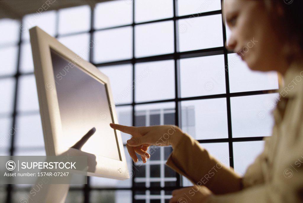 Stock Photo: 1574R-07247 Low angle view of a businesswoman pointing to a computer monitor