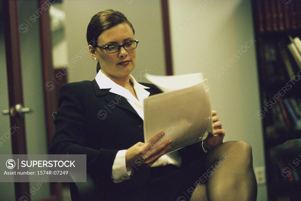 Stock Photo: 1574R-07249 Portrait of a businesswoman sitting on a chair reading papers