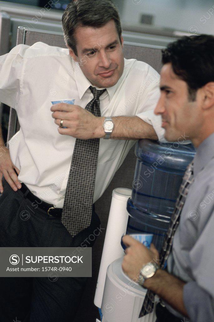 Stock Photo: 1574R-0940 Two business executives talking at a water cooler