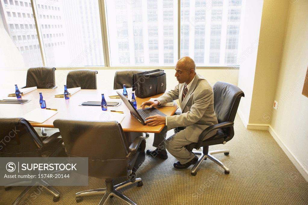 Stock Photo: 1574R-20144 Side profile of a businessman using a laptop