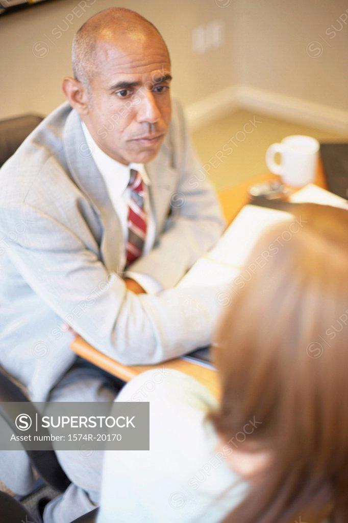 Stock Photo: 1574R-20170 High angle view of a businessman and a businesswoman talking in an office