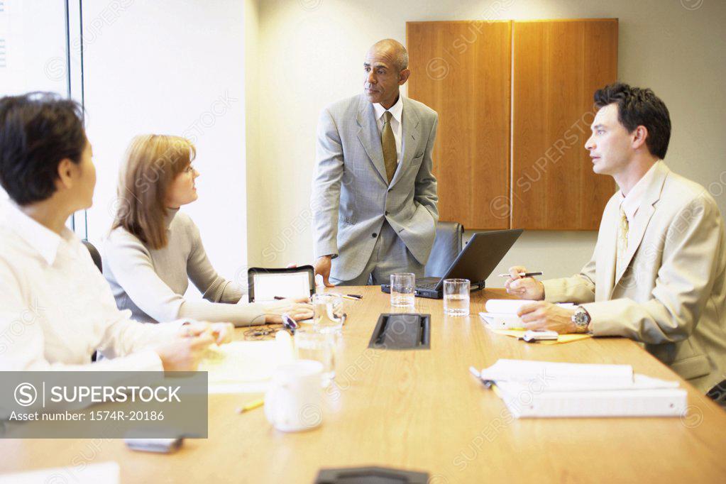 Stock Photo: 1574R-20186 Two businessmen and two businesswomen talking in a conference room