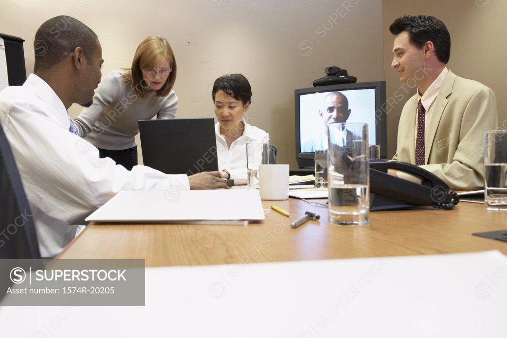 Stock Photo: 1574R-20205 Two businessmen and two businesswomen in a video conference