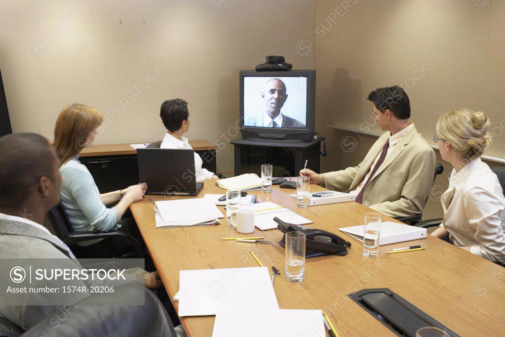 Stock Photo: 1574R-20206 Business executives looking at the television in a video conference