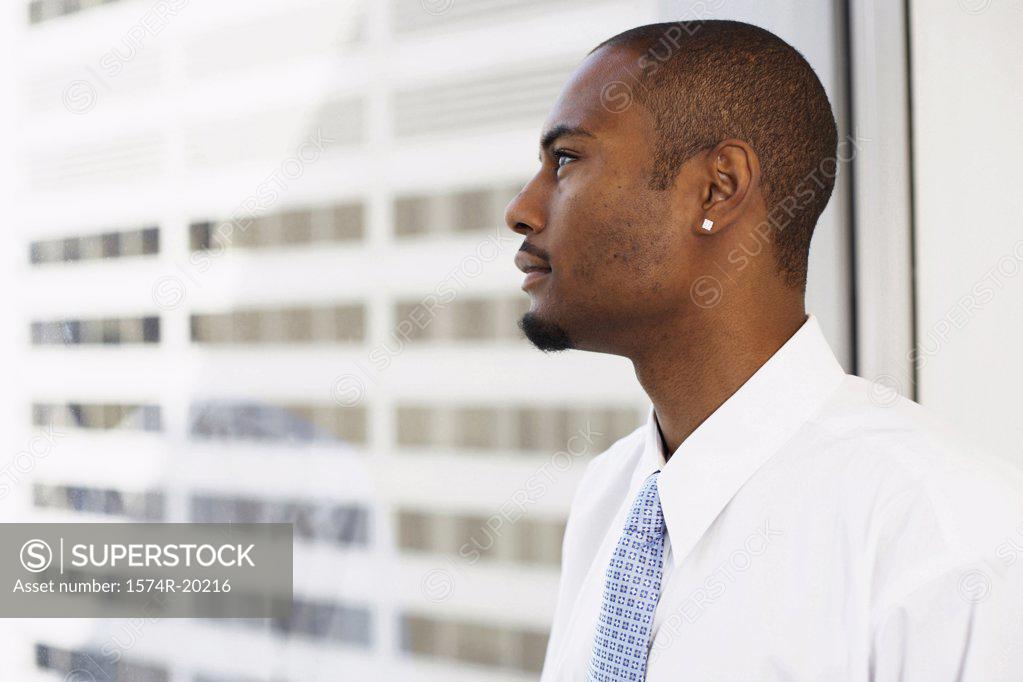 Stock Photo: 1574R-20216 Side profile of a businessman looking through a window