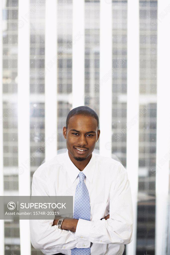 Stock Photo: 1574R-20219 Businessman standing in front of a window and smiling