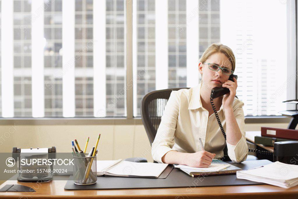 Stock Photo: 1574R-20224 Portrait of a businesswoman talking on the telephone in an office