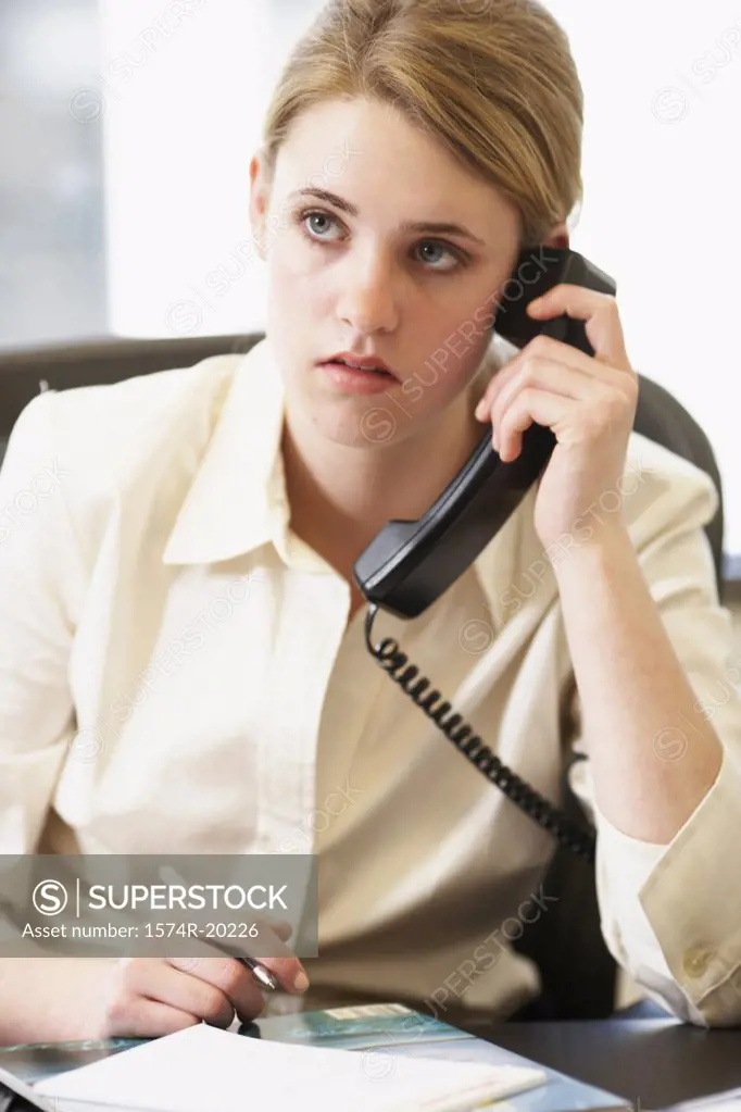 Close-up of a businesswoman using a telephone in an office