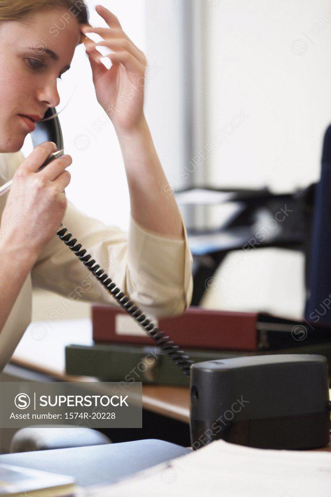 Stock Photo: 1574R-20228 Close-up of a businesswoman talking on the telephone in an office