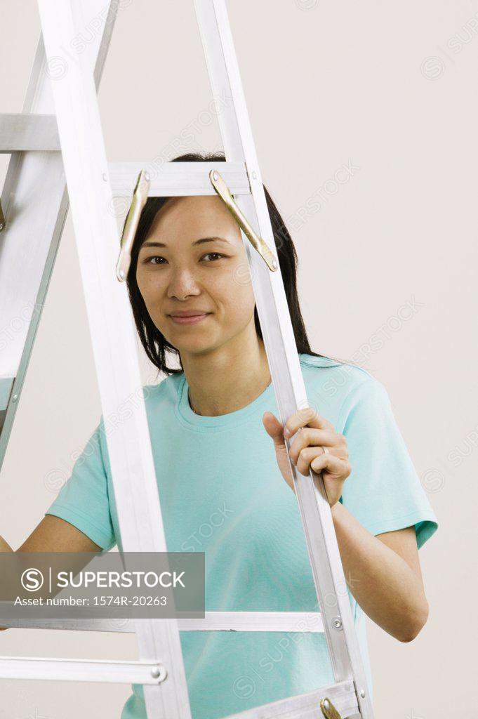 Stock Photo: 1574R-20263 Portrait of a young woman holding a ladder