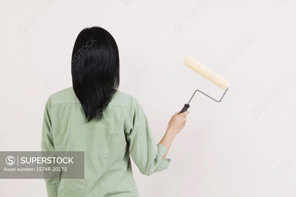 Stock Photo: 1574R-20273 Rear view of a woman holding a paint roller
