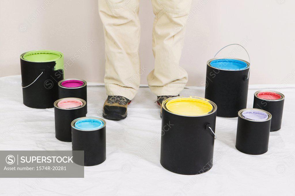 Stock Photo: 1574R-20281 Low section view of a woman standing with paint cans around him
