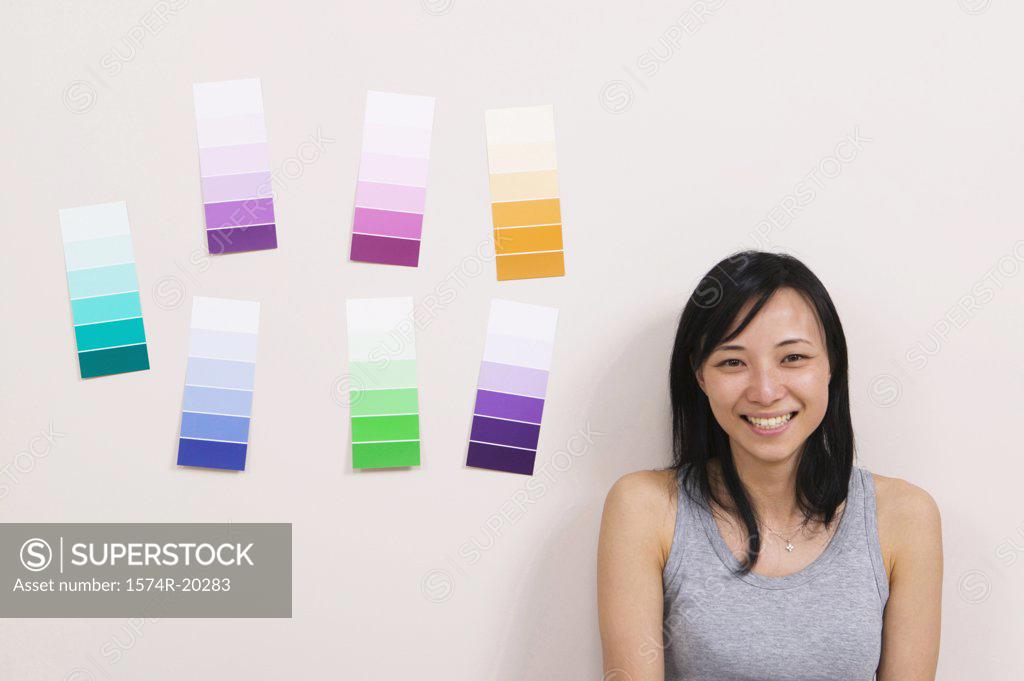 Stock Photo: 1574R-20283 Close-up of a young woman smiling with color swatches on a wall