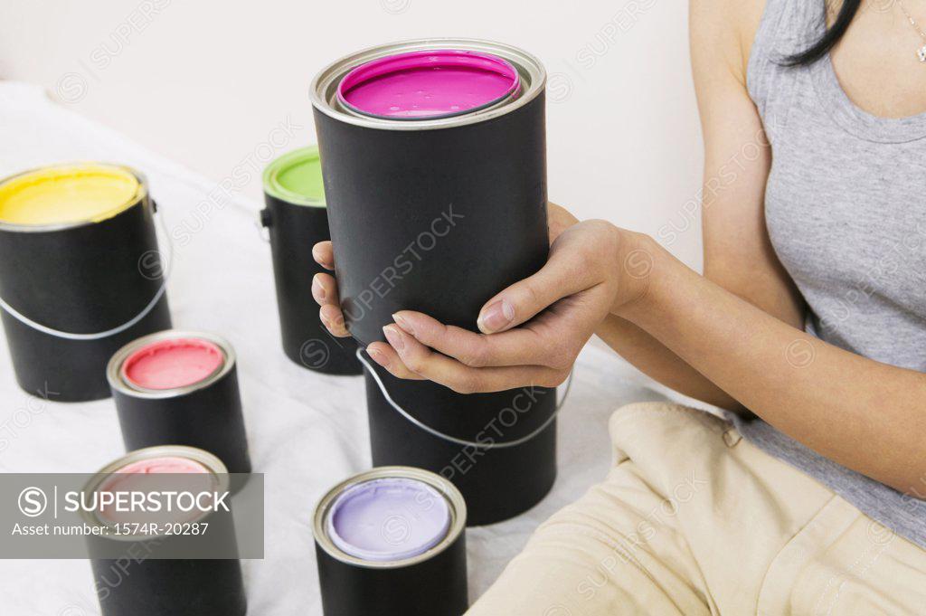 Stock Photo: 1574R-20287 Mid section view of a woman holding a paint can