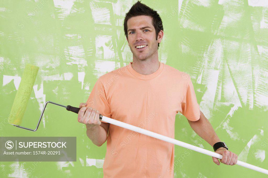 Stock Photo: 1574R-20291 Portrait of a young man holding a paint roller
