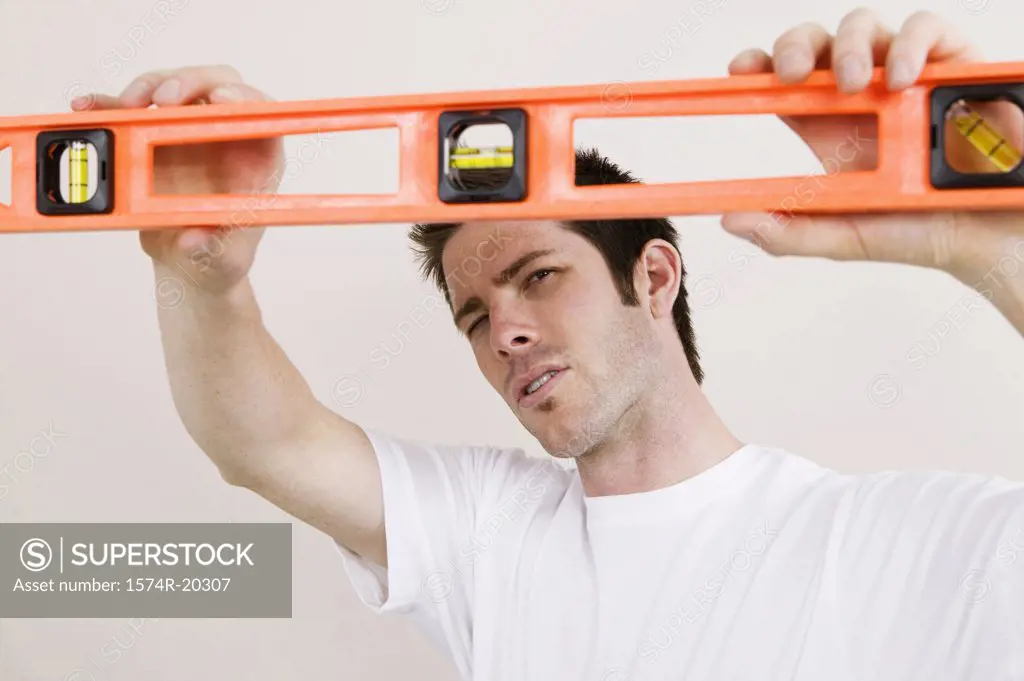 Close-up of a young man holding a spirit level