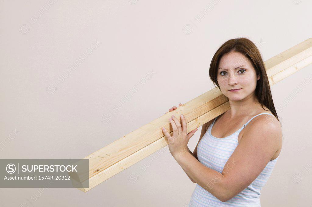 Stock Photo: 1574R-20312 Portrait of a young woman carrying planks on her shoulders