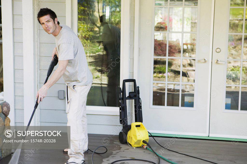 Stock Photo: 1574R-20328 Portrait of a young man cleaning the porch of his house