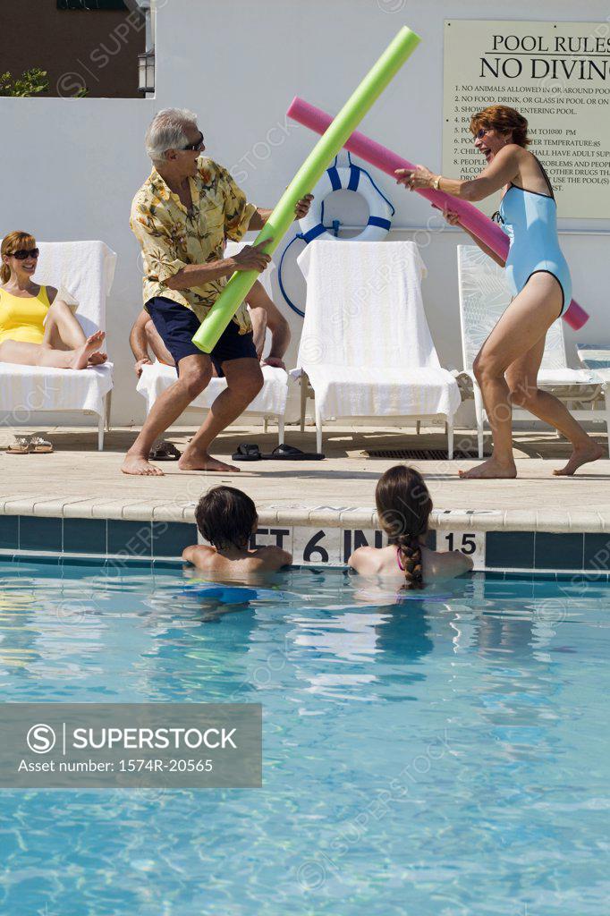Stock Photo: 1574R-20565 Side profile of a senior couple playing at poolside