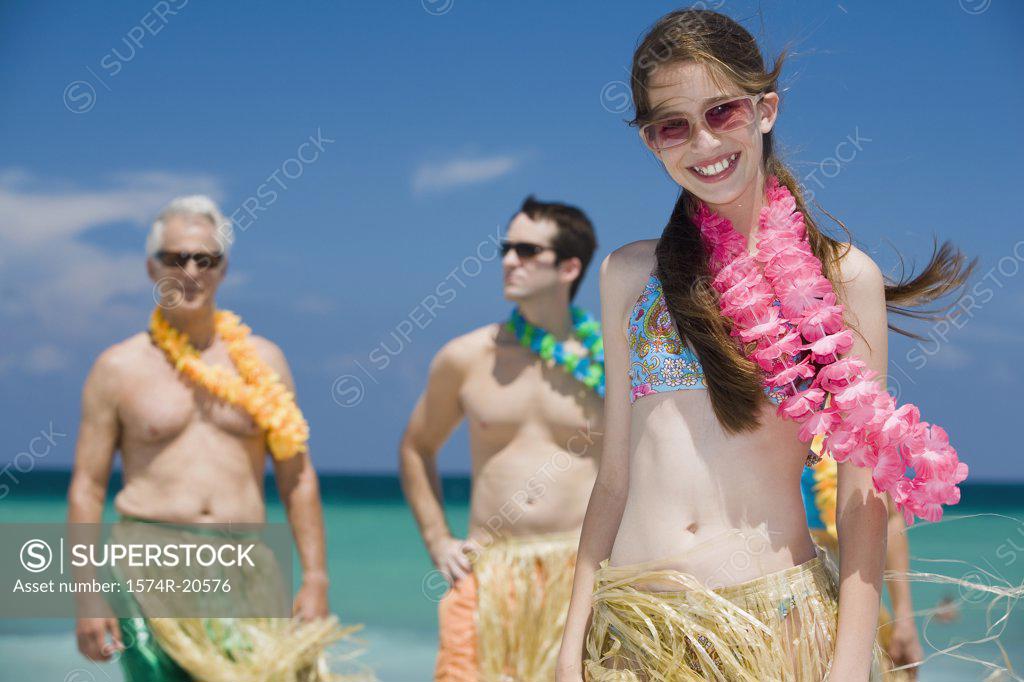 Stock Photo: 1574R-20576 Close-up of a girl smiling with her grandfather and father standing behind her on the beach