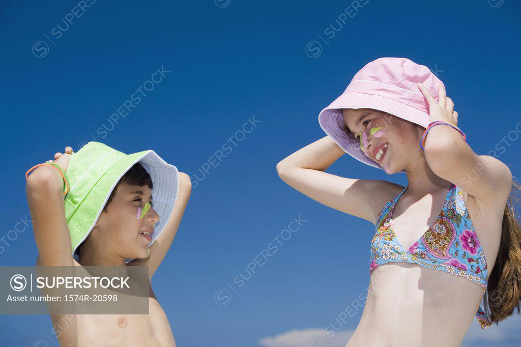 Stock Photo: 1574R-20598 Side profile of a boy and his sister looking at each other and smiling