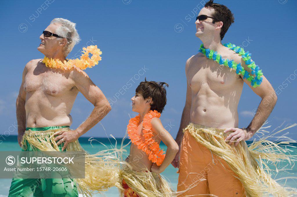 Stock Photo: 1574R-20606 Side profile of a boy standing with his father and grandfather on the beach