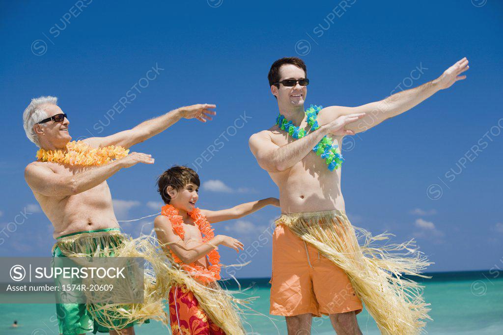 Stock Photo: 1574R-20609 Boy hula dancing with his grandfather and father on the beach