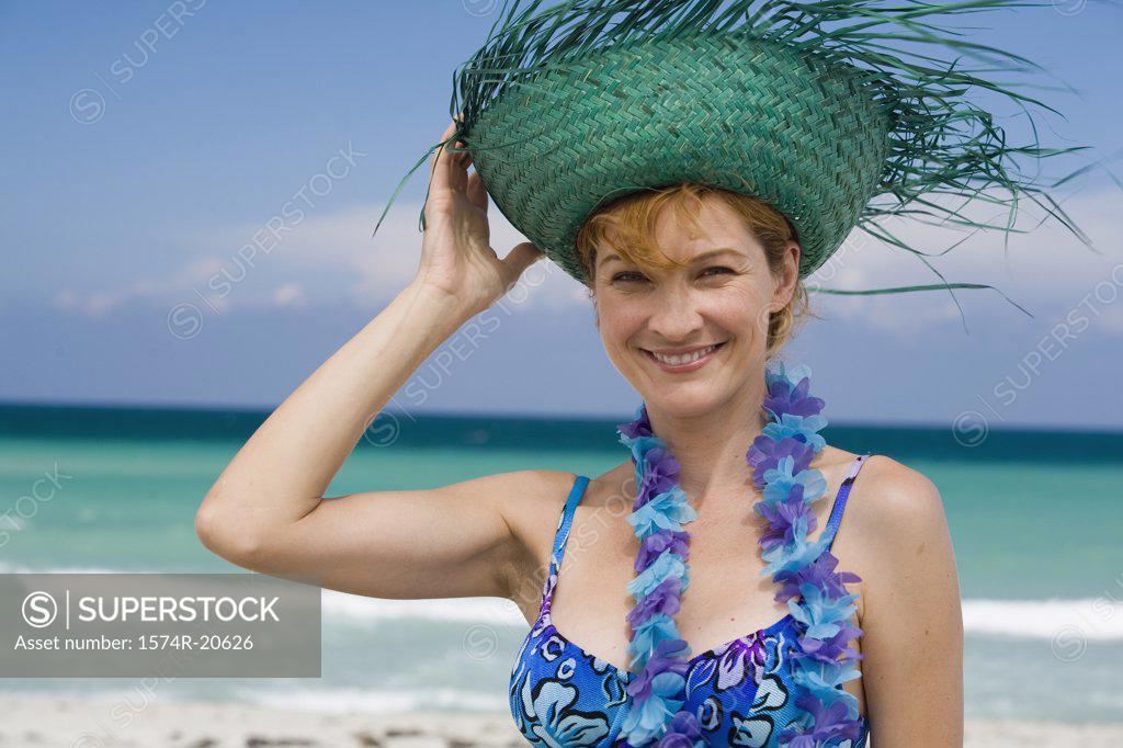 Stock Photo: 1574R-20626 Portrait of a young woman wearing a straw hat and smiling