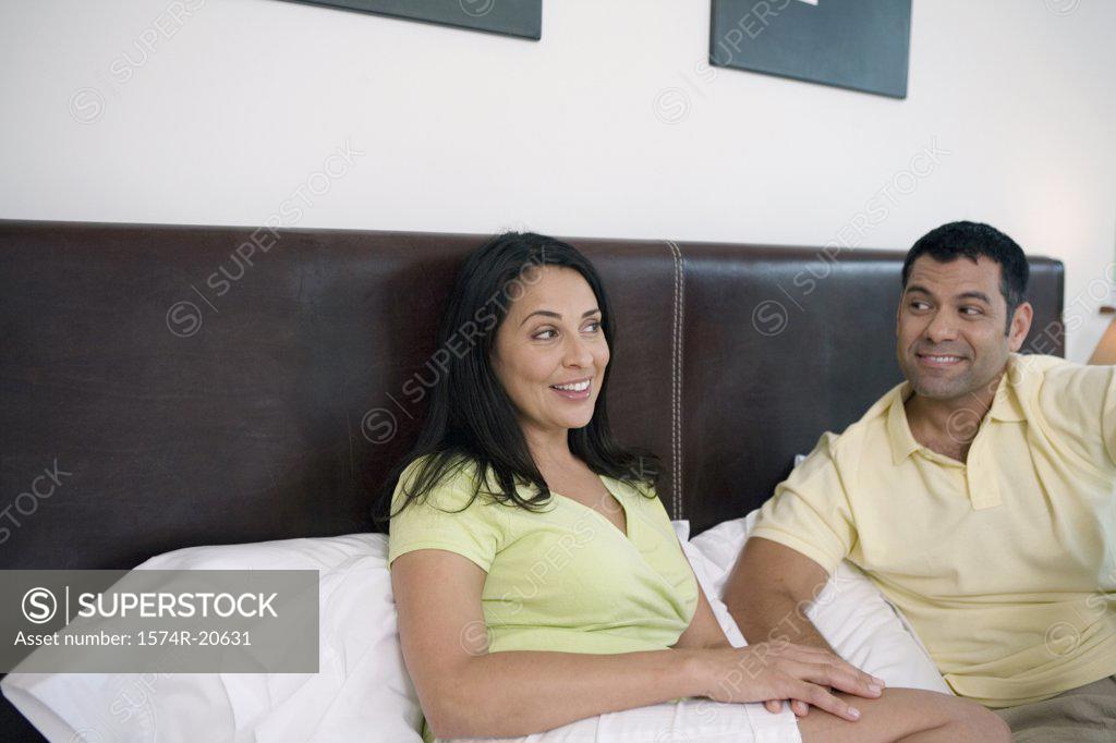 Stock Photo: 1574R-20631 Close-up of a mature couple reclining in the bed and smiling