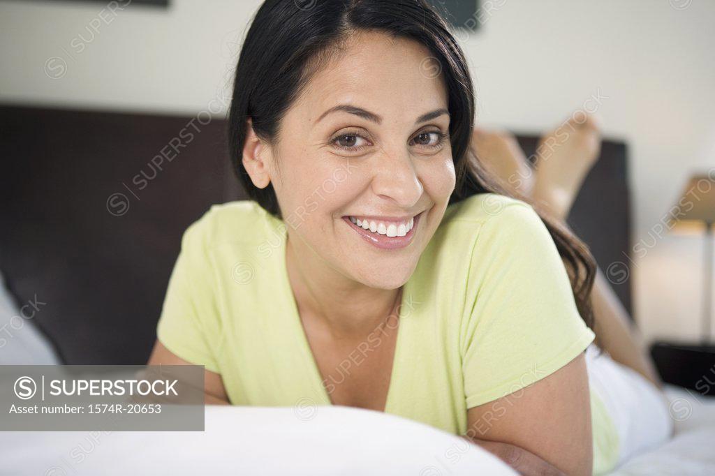 Stock Photo: 1574R-20653 Portrait of a mature woman lying in the bed and smiling