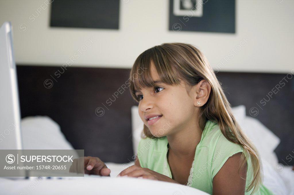 Stock Photo: 1574R-20655 Close-up of a girl lying in the bed and using a laptop