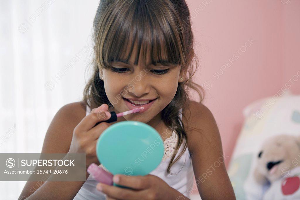 Stock Photo: 1574R-20676 Close-up of a girl applying lipstick