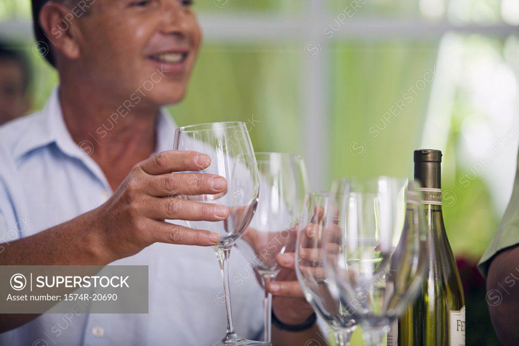Stock Photo: 1574R-20690 Close-up of a mature man holding wineglasses