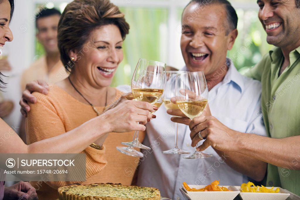 Stock Photo: 1574R-20694 Close-up of two mature couples toasting with wineglasses and smiling