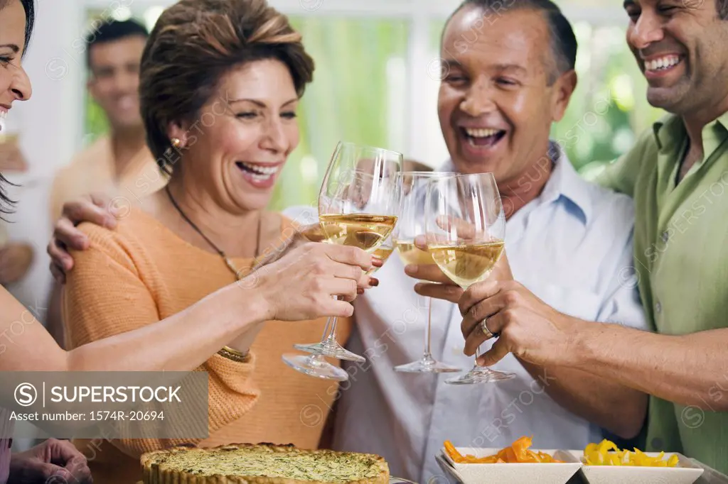 Close-up of two mature couples toasting with wineglasses and smiling