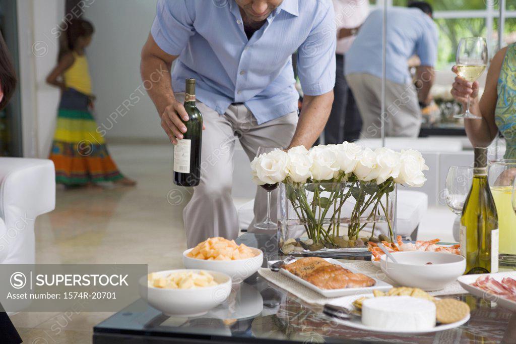 Stock Photo: 1574R-20701 Mature man standing near a mature woman holding a wine bottle
