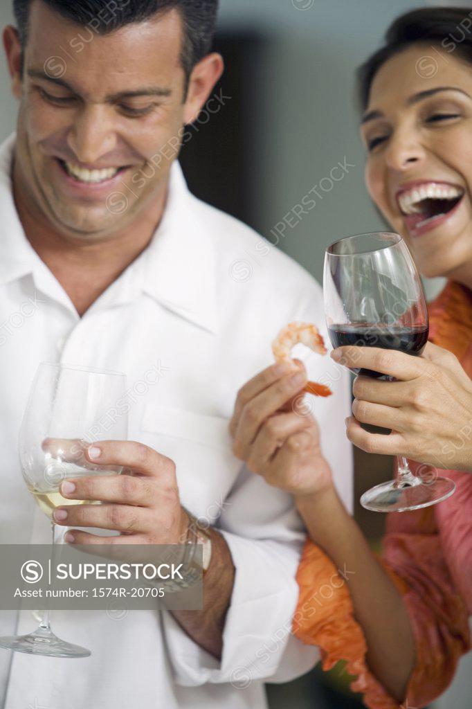 Stock Photo: 1574R-20705 Close-up of a mid adult couple holding glasses of wine and smiling