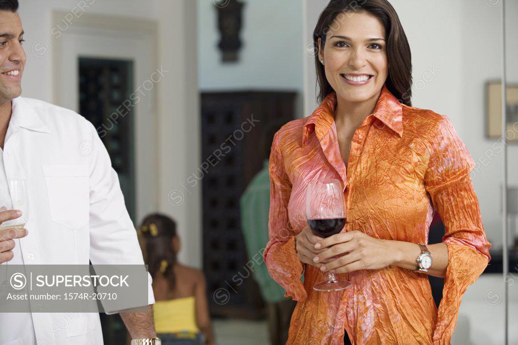 Stock Photo: 1574R-20710 Portrait of a mid adult woman standing with a mid adult man holding wineglasses