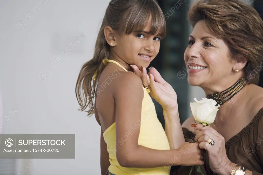 Portrait of a girl giving a flower to her grandmother